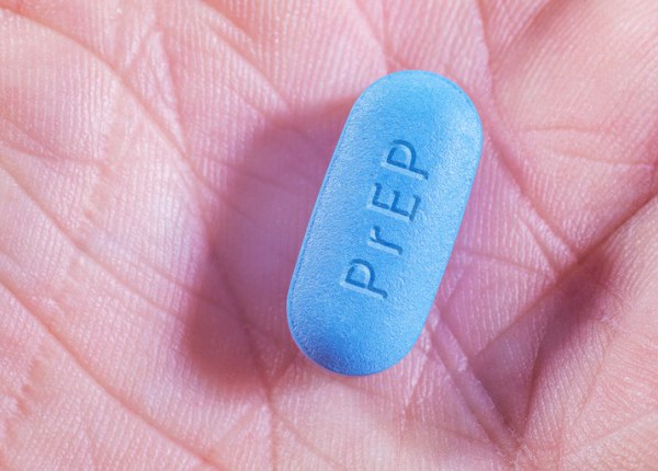 A PrEP pill in the palm of a person's hand.
